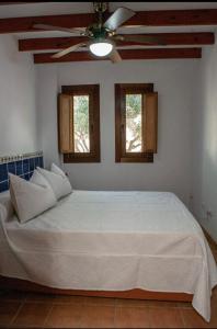 a bedroom with a large white bed with two windows at El Rincón de los Albaricoques in Níjar