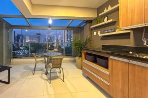 a kitchen with a table and a view of the city at Apto incrivel a 50m do metro Butanta em Sao Paulo in Sao Paulo