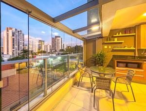 Apto incrivel a 50m do metro Butanta em Sao Paulo في ساو باولو: شرفة مع طاولة وكراسي وإطلالة على المدينة