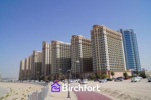 a group of tall buildings next to a beach at Birchfort - Newly Renovated Huge 2 bedroom apartment in Dubai