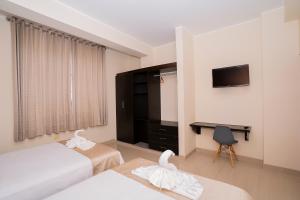 a hotel room with two beds and a television at Tropical City in Tarapoto +11 photos