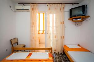 a small room with two beds and a television at Apartments Marko in Tivat