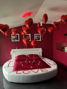 a room with a bed with red hearts on the wall at Loft d'amour in Ligné