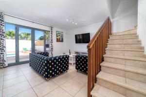sala de estar con escaleras y puerta corredera de cristal en Casa LAGO, en Playa Blanca