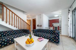 Una sala de estar con sofás y un bol de fruta sobre una mesa. en Casa LAGO, en Playa Blanca