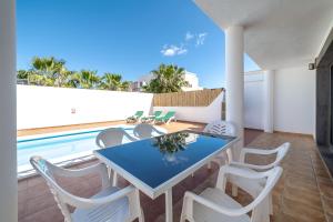 Un balcón con mesa y sillas y una piscina. en Casa LAGO, en Playa Blanca