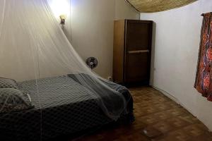 um quarto com uma cama e uma rede mosquiteira em Case beach em Ngalou Sessène