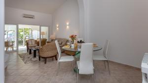 uma sala de jantar e sala de estar com mesa e cadeiras em Casa Julia - Dunas Douradas em Faro