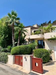 a house with a palm tree in front of it at "La Villa Bali", en Bord de Mer à 5 mn des plages avec Piscine à cascade, Grand extérieur unique sur le thème de Bali in Six-Fours-les-Plages