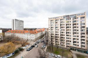 a city street with cars parked in front of buildings at Ratusz Arsenał Modern City Apartment in Warsaw