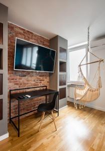 a living room with a hammock hanging from a brick wall at Ratusz Arsenał Modern City Apartment in Warsaw