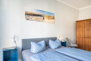 1 dormitorio con 1 cama con almohadas azules y armario en Haus Ferienglück Sauna im Haus, en Ostseebad Sellin