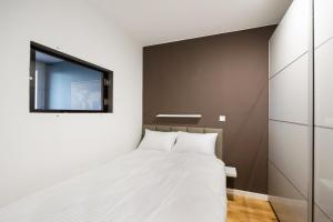 a bedroom with a bed and a tv on the wall at Ratusz Arsenał Modern City Apartment in Warsaw