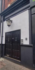 un edificio blanco y negro con una puerta y una lámpara en Yarm Lane Apartments - Stockton Town Centre, en Stockton-on-Tees