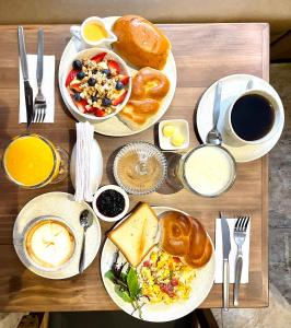 a wooden table with plates of breakfast foods and coffee at Casa Montes San Blas in Cusco