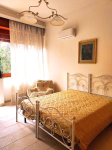 een slaapkamer met een bed, een stoel en een raam bij Villetta Hydro 3 in Bagnolo del Salento