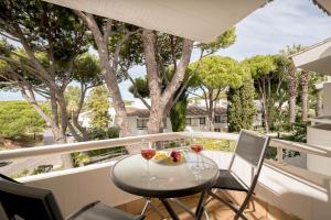 a table with two glasses of wine on a balcony at Apartment Victoria - Quinta do Lago in Quinta do Lago