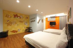 a hotel room with two beds and a tv at Bears Line B&B train station in Hualien City
