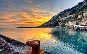 a sunset over a body of water with a mountain at Incentro 44 in Cava deʼ Tirreni