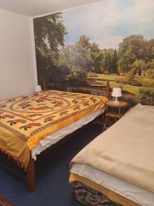 two beds in a room with a painting on the wall at Ubytovanie u Marty in Veľký Meder
