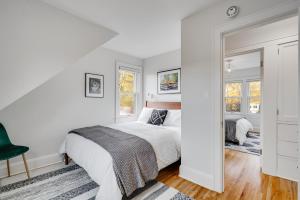 a white bedroom with a bed and a mirror at Nokomis Blue in Minneapolis
