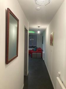 a hallway with a living room with a red couch at Bel appart stylé avec jacuzzi in Sedan