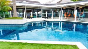 a swimming pool in front of a house at Holiday Inn Auckland Airport by IHG in Auckland