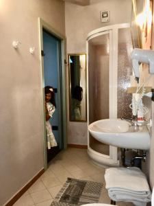 a woman taking a picture of a bathroom with a sink at Villa Monica in Brentonico