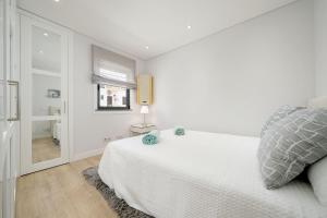 a white bedroom with a bed and a window at Casa Alessa - Vale de Lobo in Almancil