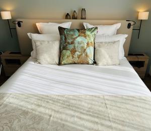 a bed with white sheets and pillows on it at Residhome Quai d’Ivry in Ivry-sur-Seine