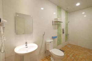 ein Badezimmer mit einer weißen Toilette und einem Waschbecken in der Unterkunft Bears Line B&B train station in Hualien