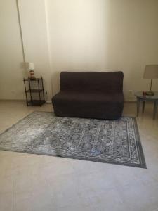 un sofá sentado en una alfombra en una sala de estar en Maravilhoso apartamento T2 Estoi, en Estói