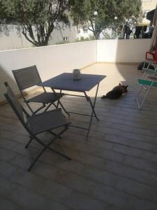 un gato negro tirado junto a una mesa y sillas en Maravilhoso apartamento T2 Estoi, en Estói