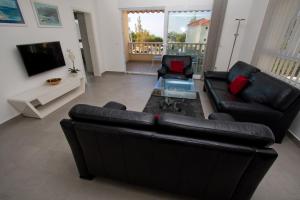 a living room with a black leather couch and a tv at Luxury Apartment Marko in Promajna