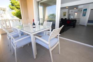 - une table à manger blanche avec des chaises blanches et une bouteille de vin dans l'établissement Luxury Apartment Marko, à Promajna