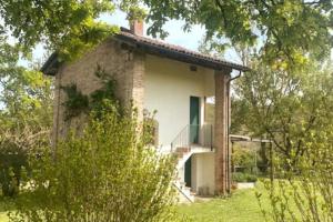 an old brick house with a balcony in a field at Cottage sui colli Bolognesi in Bologna