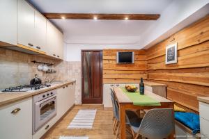a kitchen with wooden walls and a table with a bottle of wine at Apartament Nordic in Gura Humorului