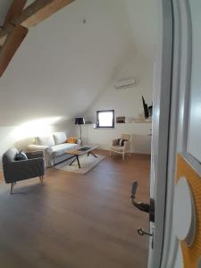ein Wohnzimmer mit einem Sofa und einem Tisch in der Unterkunft Le Repaire de Bacchus in Saint-Nicolas-de-Bourgueil
