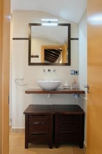 ein Bad mit einem Waschbecken und einem Spiegel in der Unterkunft Casa de pueblo adosada, en la zona rural de Gijón. in Gijón