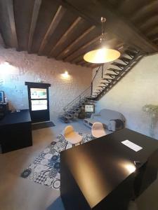 a room with a table and chairs and a staircase at Le Repaire de Bacchus in Saint-Nicolas-de-Bourgueil