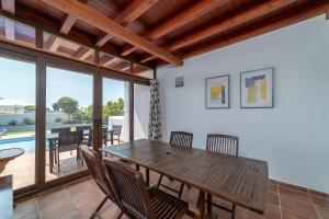 a dining room with a wooden table and chairs at Villa Alba in Playa Blanca