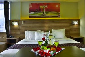 Una habitación de hotel con una bandeja de fruta y bebidas en una cama en Terramística Arequipa - Monasterio, en Arequipa