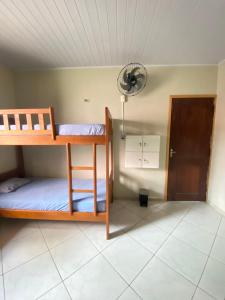 バヘイリーニャスにあるLazer Hostelの二段ベッド2台、壁掛け時計が備わる客室です。