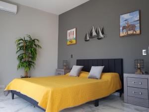 a bedroom with a bed with a yellow blanket at Casa Moreno Deluxe in Ameca