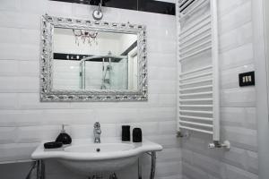 a white bathroom with a sink and a mirror at Portobello Appartamento 3 camere 3 bagni in Taranto
