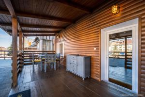 a patio with a table and chairs on a deck at Apartament Nordic in Gura Humorului