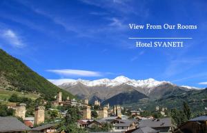 una vista di una città con le montagne sullo sfondo di Hotel Svaneti a Mestia