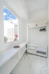 アテネにあるOlvar's Modern Luminous Suite , Athens Downtownの窓と白いテーブルが備わる白い部屋