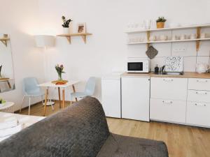 una cocina con armarios blancos y una mesa con sillas. en Apt 100 Prague, en Praga