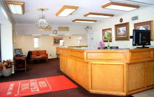 uma sala de espera com um grande bar de madeira numa clínica em Red Carpet Inn - Natchez em Natchez
